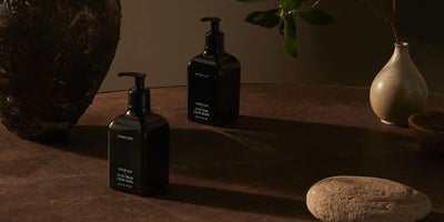 Vegan household products by Homecourt in dark bottles displayed with earthy tones and minimal ceramic decor.