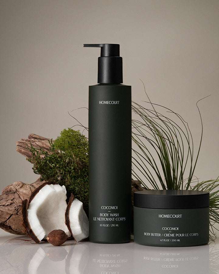 Front view of Bodycare Duo showcasing dark green pump body wash and body butter jar with coconut and wood on beige background