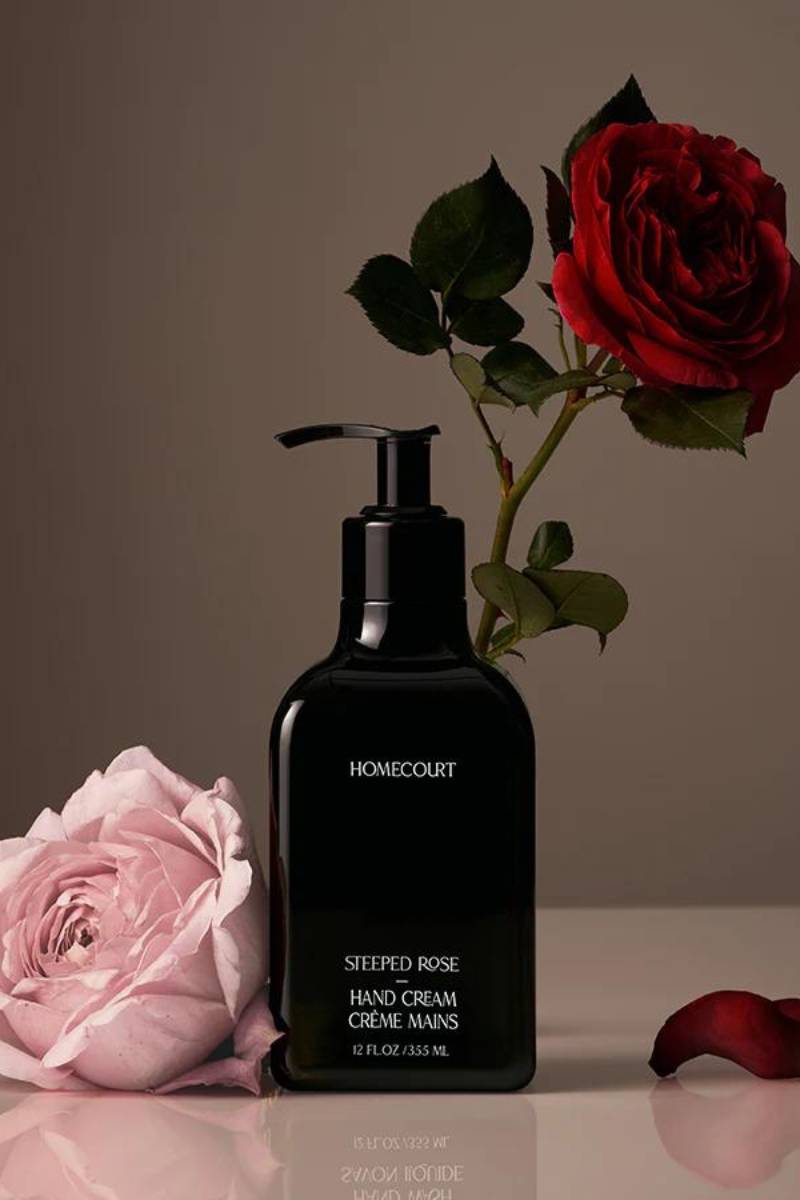 Front view of HOMECOURT Steeped Rose hand cream pump (12 fl oz) showcasing glossy black bottle with rose blooms