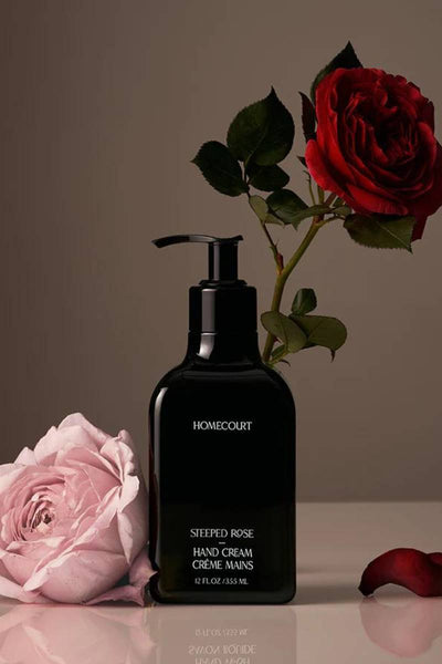 Front view of HOMECOURT Steeped Rose hand cream pump (12 fl oz) showcasing glossy black bottle with rose blooms
