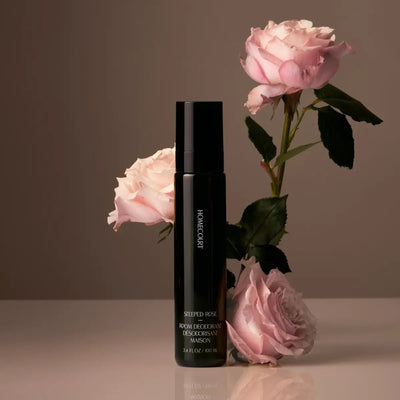 Front view of Homecourt Steeped Rose room deodorant showcasing a sleek black spray bottle with pink roses against a neutral studio background