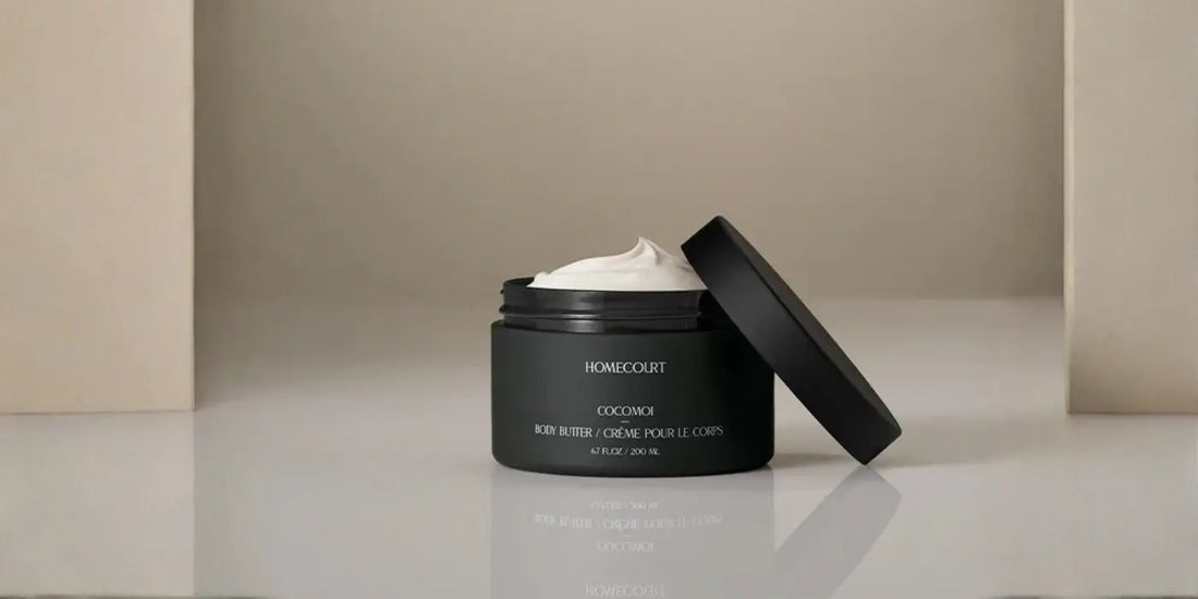 Moisturizing balm in dark jar with creamy texture and black lid on neutral background