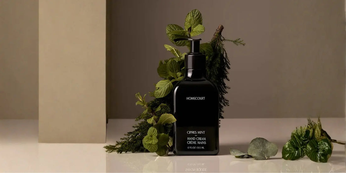 Premium hand cream cipres mint scent in black bottle displayed among fresh mint and forest botanicals