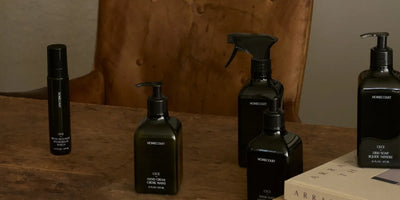 Home fragrance products including room deodorant and hand care from Homecourt arranged on a rustic wooden table.