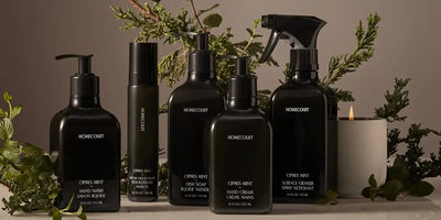 Healthy dish detergent and complete Homecourt Cipres Mint cleaning collection styled with greenery and a candle.