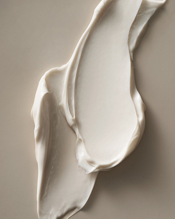 Shea body butter swirled on a smooth surface, highlighting its rich, creamy texture and nourishing consistency.
