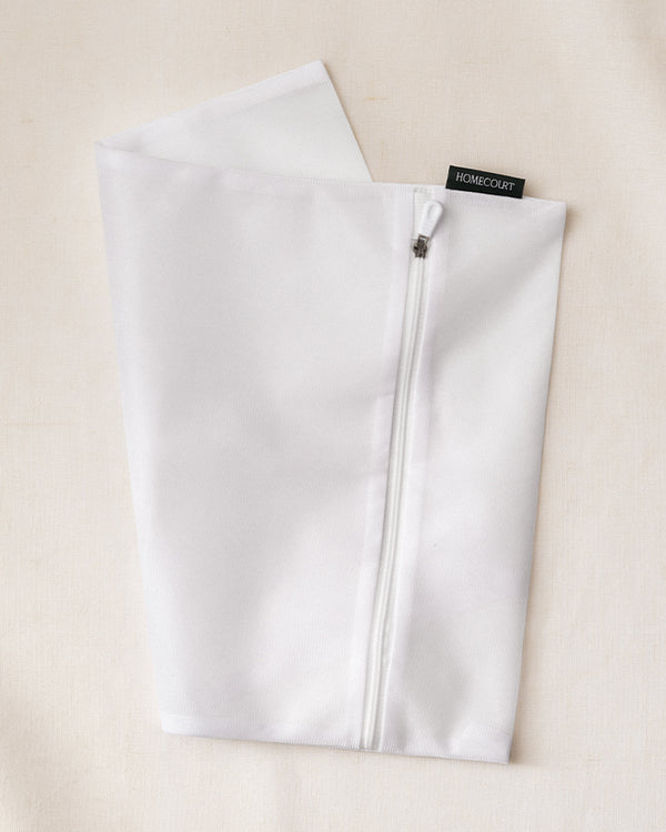 Laundry delicates bag made of white mesh fabric with zipper closure, ideal for protecting delicate garments in the wash.