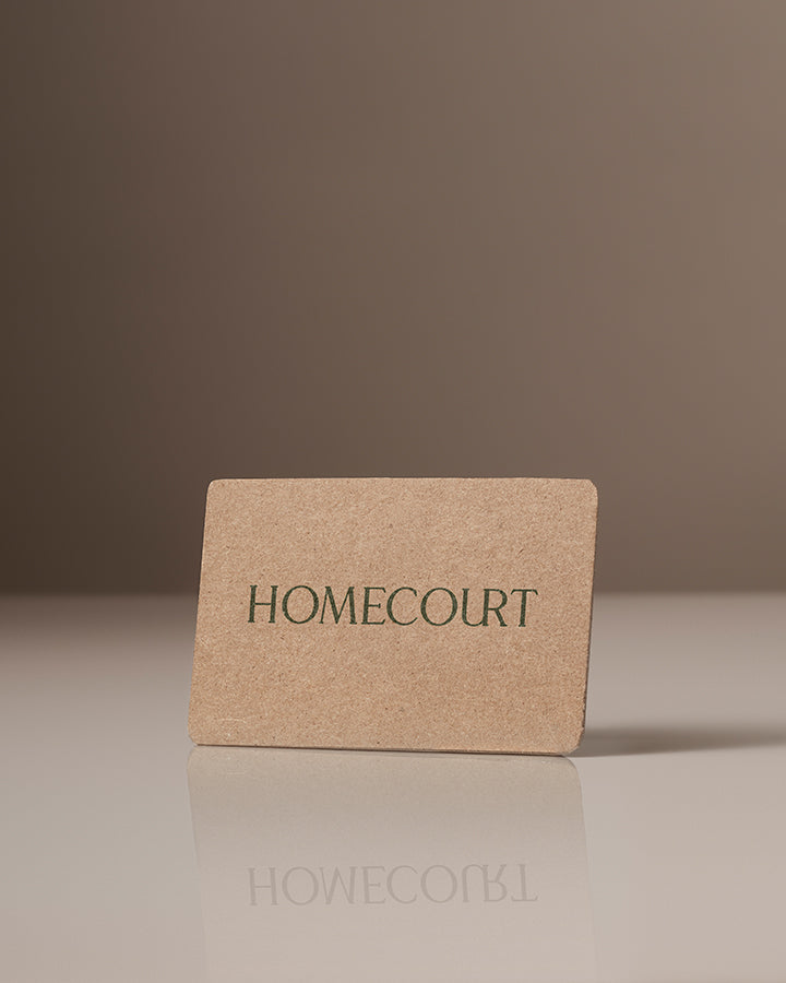 Homecourt gift card made of brown textured material with green logo text.