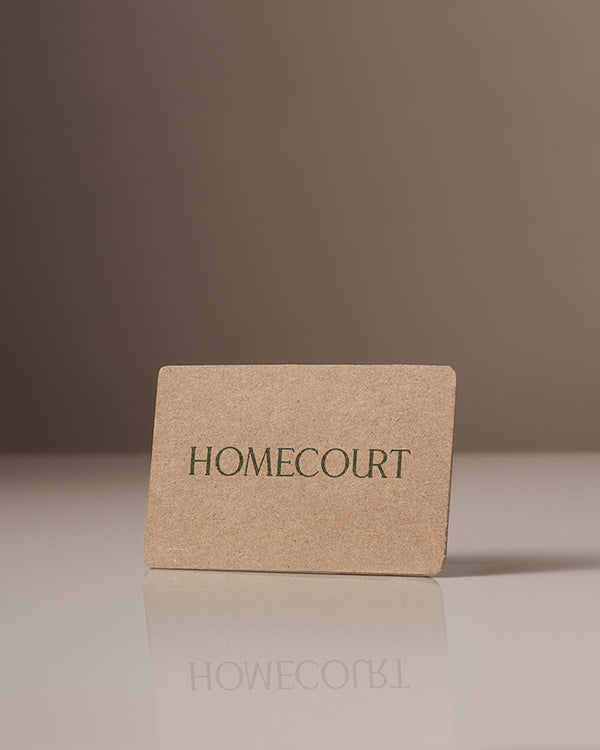 Homecourt gift card made of brown textured material with green logo text.